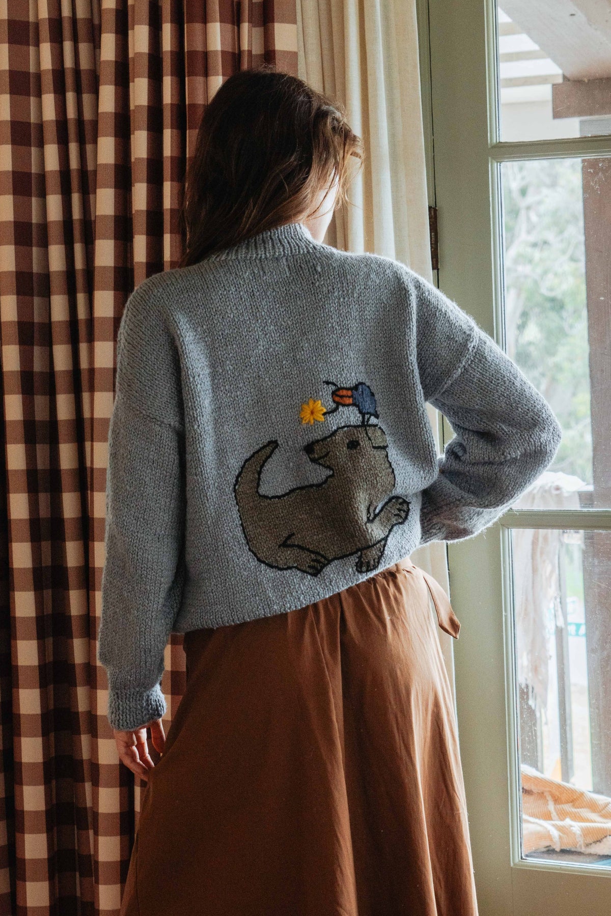 Close view of the dog and bird graphic on the back of the Banjo Blue artisan-made alpaca wool sweater
