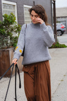 Woman walking in the Banjo Blue Best Buds hand-knit sweater, mock neck and oversized fit