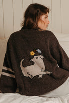 Close view of the Buster Brown artisan-made sweater back, cream knit dog with a bird on its head and sleeve stripes